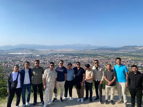 Müstesna Gençlik Kulübü üyeleri şehir ve dağ manzarası önünde birlikte
